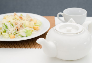 Caesar salad, kettle and Cup of tea