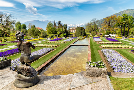 Landscape of Botanical Gardens of Villa Taranto with bronze statue The Fisher in front, Pallanza, Verbania, Italy.
