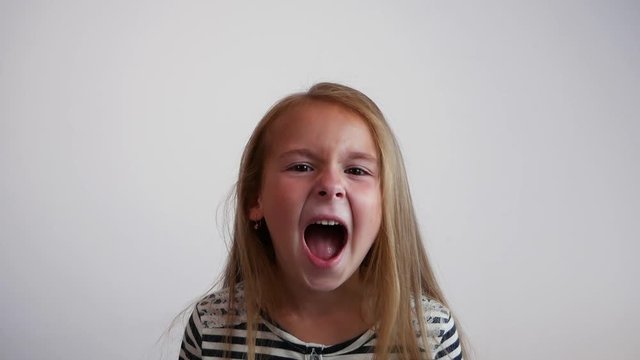 Pretty young girl shouting on white background. Slow motion
