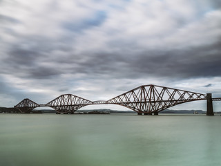 Long exposure shot of the iconic Forth Rail Bridge spanning over the Firth of Forth viewed from South-Queensferry. Scotland, UK