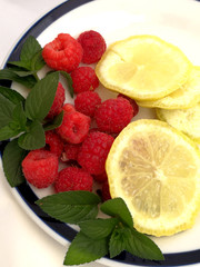 Plate with raspberries and lemon slices