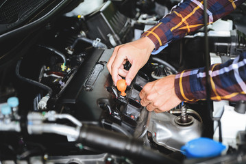 Close up hands checking lube oil level of car engine from deep-stick for service and maintenance...
