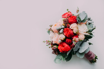 Wedding bouquet of red and cream roses on a light floor. Top view