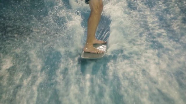 People practice surfing It's a aquapark, extreme athlete on shortboard, surfboard on wave attraction, happy sport people, close legs on board on vawe