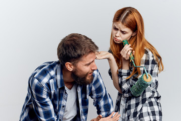 Young beautiful woman with a guy with a beard on white isolated background, repair, construction tools