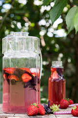 Lemonade detox strawberry basil. refreshing drink with fresh strawberry and basil on the background of the garden