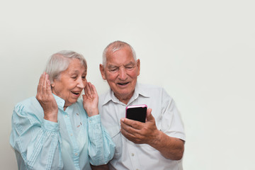Senior couple at home using smartphones