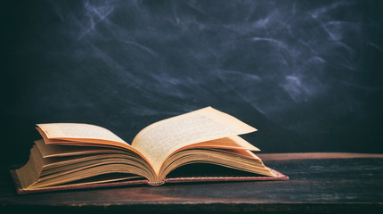 Vintage book on blackboard background