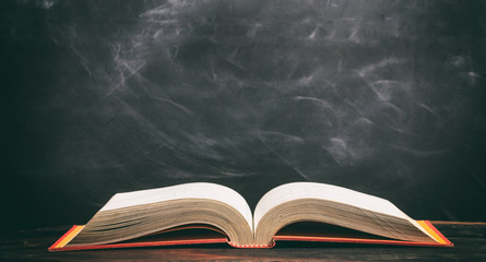 Vintage book on blackboard background