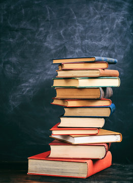 Vintage books stack on blackboard background