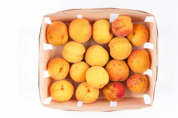 Peaches, apricots and plums in a basket isolated on white background