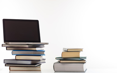 Books stack and a laptop on white background