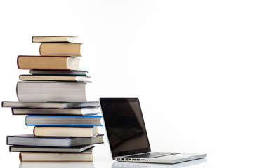 Books stack and a laptop on white background