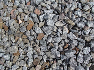 Background of large gray-red-brown rubble. Crushed gravel close-up - top view