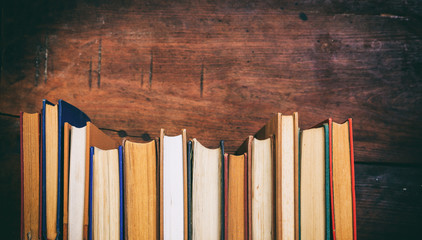 Vintage books on wooden background - copy space