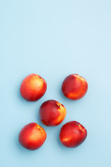 A few ripe nectarines on a blue background