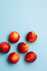 A few ripe nectarines on a blue background