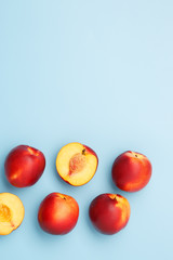 A few ripe nectarines on a blue background