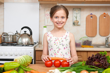 Child girl having fun with tomatoes. Home kitchen interior with fruits and vegetables. Healthy food concept