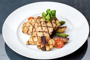 Grilled chicken fillet with french fries and asparagus