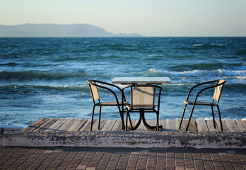Fototapeta na wymiar Table and chairs on the beach in the early summer morning