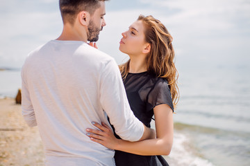 Beautiful Couple At Beach.Outdoor portrait happy beautiful couple,couple having fun by sea,enjoy vacation,trendy hipster look,happiness,love,summer holidays,man touching girlfriend,tan