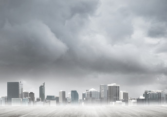 Fototapeta premium Modern urban buildings skyscrapers blue cloudy sky background and wooden textured platform