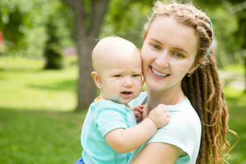 Portrait of happy loving mother and her baby boy playing in park. happy family outdoors.
