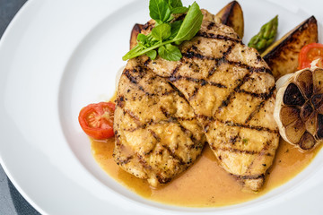 Grilled chicken fillet with french fries and asparagus