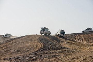 Vehicles driving in dusty desert