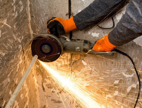 Worker cuts a metal pipe at a construction site