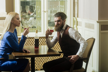 Woman and man drinking from martini glasses
