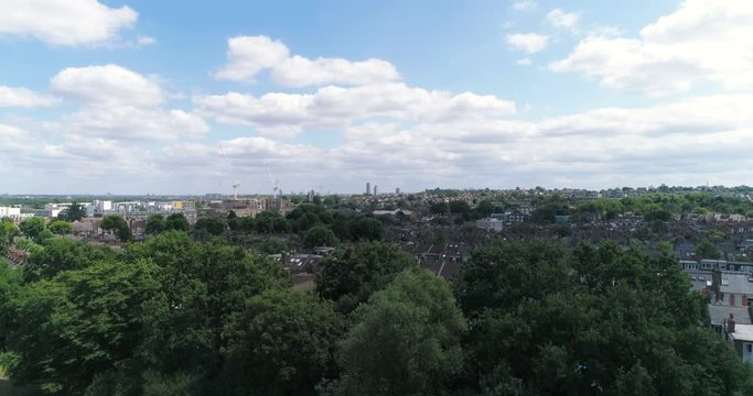 Aerial ascending view of a typical Edwardian Victorian village in North London revealing the skyline of the City of London