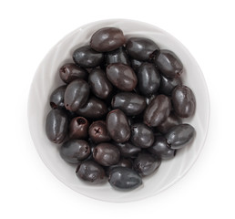 Black pitted olives in bowl isolated on white background, top view, close up.