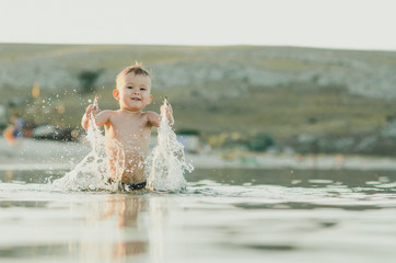 Happy baby playing in the sea