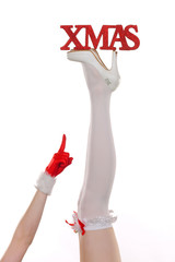 A pair of woman's legs are stretched out high in front of a white background. Christmas and winter...
