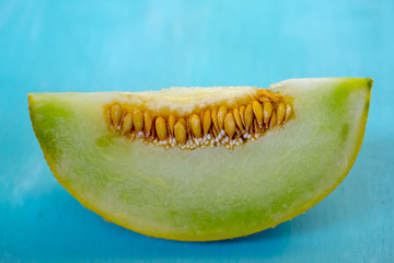 Pieces of melon on a blue wooden background