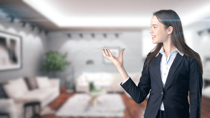 Young beautiful business woman and creative designer standing over blured interior background