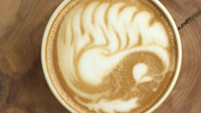 Latte art swan, top view. Cup of coffee spinning.