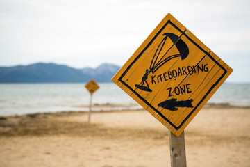 Kiteboarding, wooden kitesurfing sign on beach
