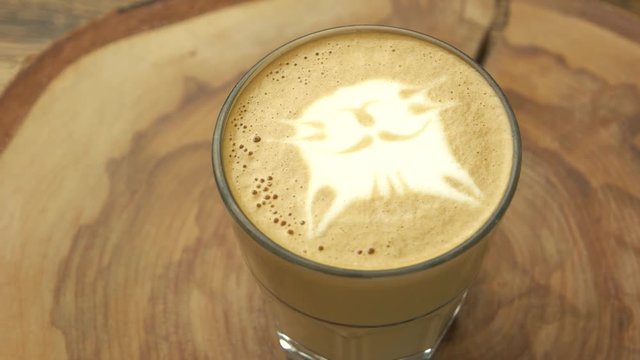 Cat face latte art. Glass with coffee beverage.