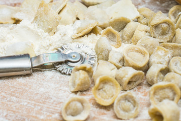 Delicious Italian ravioli on a wooden vintage wooden board, sprinkled with flour. Ravioli homemade. Top view.