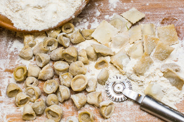  Italian ravioli on a wooden vintage wooden board, sprinkled with flour. Ravioli homemade. Top view.