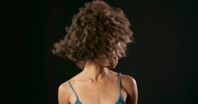 Woman with curly hair dancing in slow motion