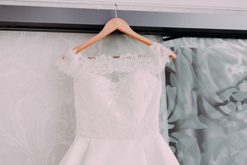 Naklejka premium White beautiful bridal dress with lace on a wooden shoulders, before wedding ceremony