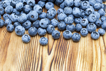 Close-up photo of fresh natural organic blueberries on brushed wooden background.  Place for text