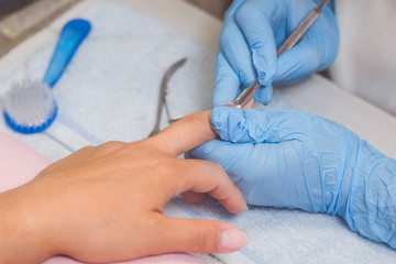 The master prepares the nails for manicure