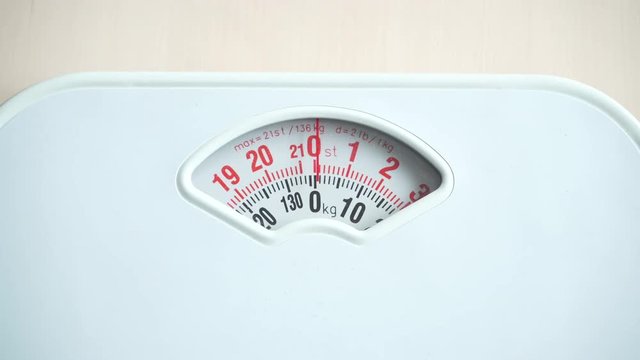Nobody. White bathroom scales weighing machine on floor. Health care, weight control concept. Rack focus 4K ProRes HQ codec