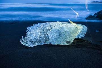 Ice cube on black beach in Iceland.