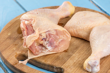 Raw chicken drumsticks on the kitchen wooden board